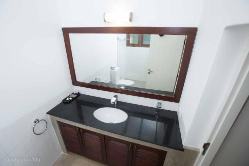 贾夫纳Jaffna Heritage Hotel的一间带水槽和大镜子的浴室