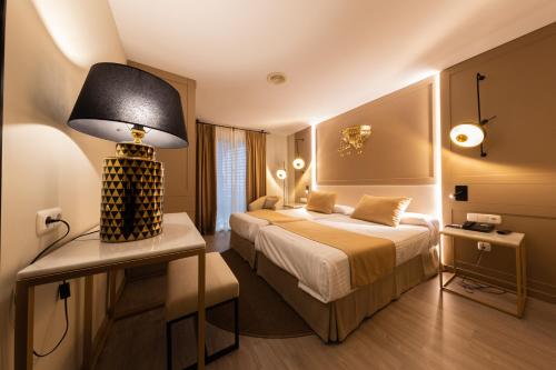 阿尔姆尼卡卡萨布兰卡酒店的酒店客房,配有床和灯