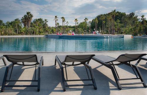 格里莫维克斯兰德假日酒店的两把椅子坐在游泳池前