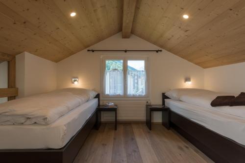 萨斯阿尔马格尔Haus Bergsonne的带窗户的客房内的两张床