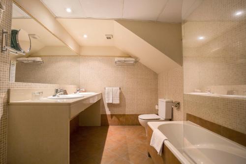 索尔德乌Hotel Himàlaia Soldeu的一间带水槽、浴缸和卫生间的浴室