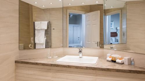 锡德茅斯维多利亚酒店的一间带水槽和大镜子的浴室
