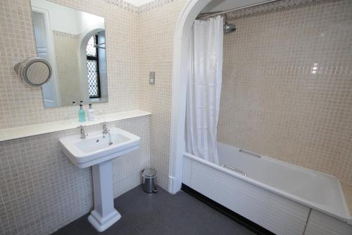 罗特莱Rothley Court Hotel by Greene King Inns的白色的浴室设有水槽和淋浴。