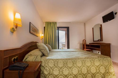 安道尔城切尔沃勒酒店的一间设有大床和窗户的酒店客房