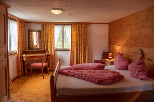 梅劳Alps Hoamat的一间卧室配有一张带红色枕头的床和一架钢琴