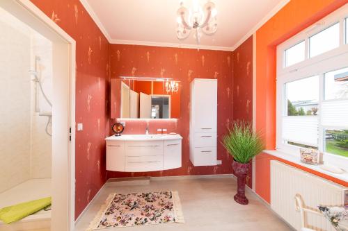 宾茨Haus Mozart的浴室设有橙色墙壁、水槽和镜子