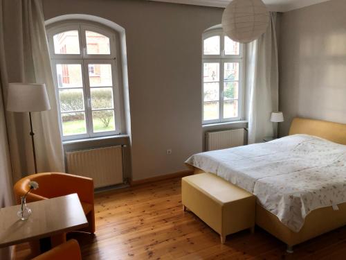 PutgartenArkona 3的卧室配有白色的床和2扇窗户。