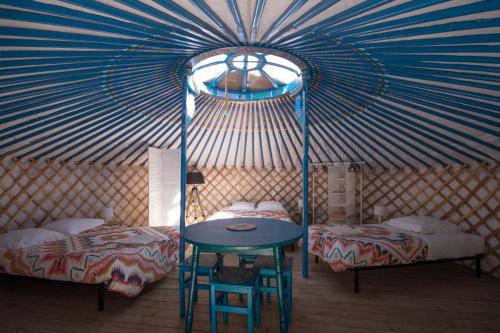 热德尔Yourtes Mongoles Gavarnie的圆顶帐篷内带两张床和一张桌子的房间