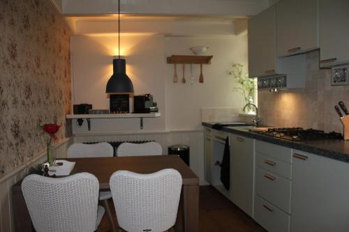 Rottevalle't Stee fan Anne P.的厨房配有木桌和白色椅子