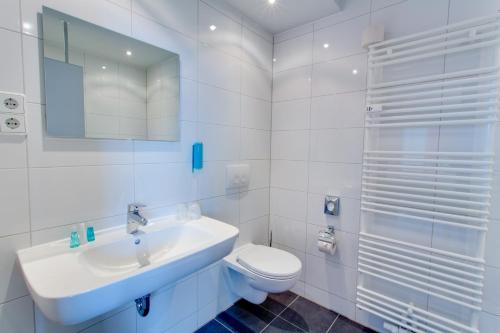 开姆尼茨比恩多酒店的白色的浴室设有水槽和卫生间。