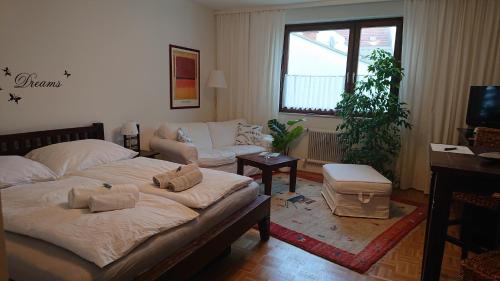 克拉根福Wohnen im Kolonialstil inklusive Tiefgarage, kontaktloser Check-in的客厅配有床和沙发