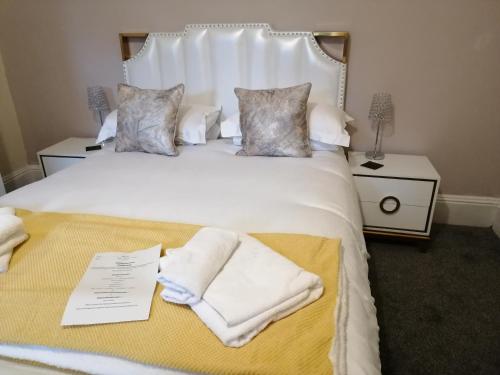 约克格利门宾馆的卧室配有带毛巾的大型白色床