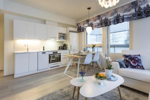 罗瓦涅米Tuomas´ luxurious suites, Livo的厨房以及带沙发和桌子的客厅。