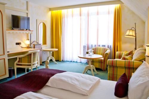 安斯巴赫凯斯巴克穆尔酒店的酒店客房带一张床、一张桌子和椅子