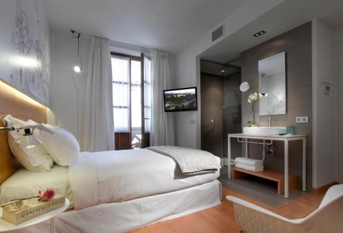 格拉纳达帕拉加西耶特酒店的卧室配有白色大床和水槽