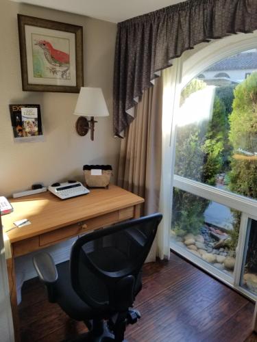 洛思加图斯Los Gatos Garden Inn Hotel的办公室,带桌子,窗户和椅子