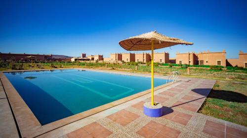 瓦尔扎扎特Ecolodge l'île de Ouarzazate的游泳池旁的遮阳伞和