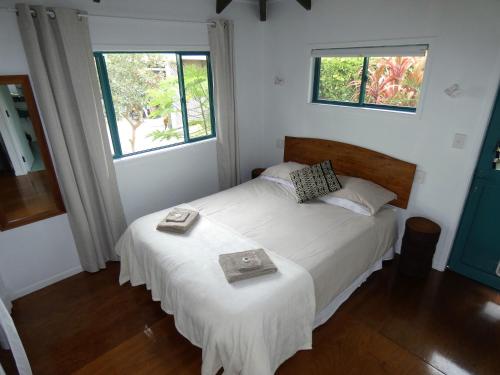 拉罗汤加Aroa Kainga Bungalows and Apartment的卧室配有白色的床和2扇窗户。