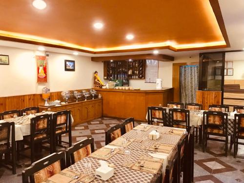 索拉哈奇特旺乡村度假酒店的一间带桌椅的餐厅和一间酒吧