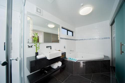 奥克兰Best Western Ellerslie International Hotel的白色的浴室设有水槽和浴缸。