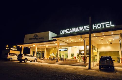 IlaganDreamwave Hotel Ilagan的梦幻般的酒店,晚上在户外停车
