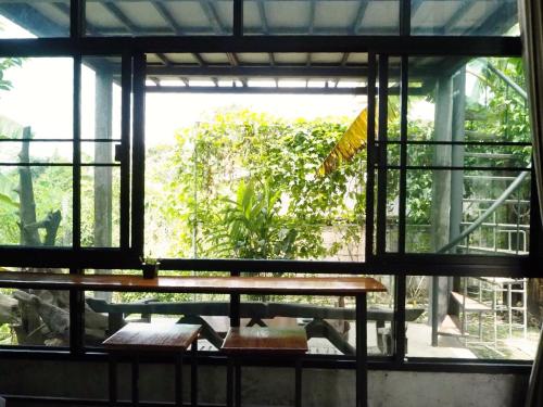Ban Muang Chum班莱克莱昂民宿的客房设有桌子和大窗户。