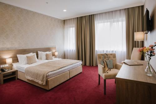 特鲁斯卡韦茨Hotel Alkor的配有一张床和一把椅子的酒店客房