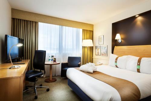 佩斯利假日格拉斯哥机场酒店的酒店客房配有一张床、一张书桌和一台电视。