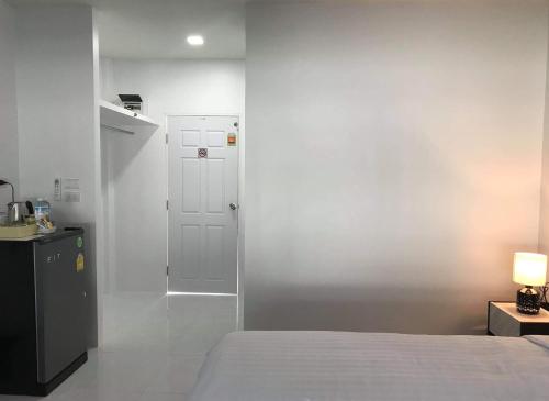 奈扬海滩Airport Pearl Residence的一间卧室设有一张床和白色的墙壁