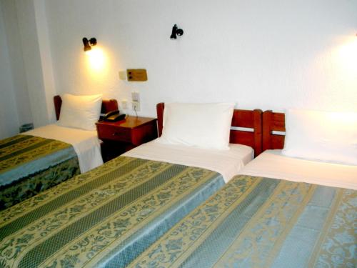 帕诺尔莫斯斯科派洛斯阿弗洛蒂提酒店的酒店客房,配有两张带白色床单的床
