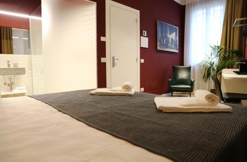 维罗纳OFFICINA TESINI Guest Rooms Verona的一间卧室配有一张床,上面有两条毛巾