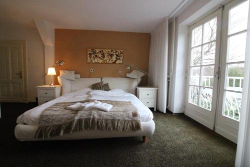 泰赫伦Villa Wambach的一间卧室设有一张大床和两个窗户。