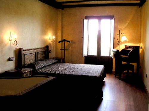 阿兰达德杜洛Hotel Rural y SPA Kinedomus Bienestar的一间卧室配有一张床、一个窗口和一张书桌
