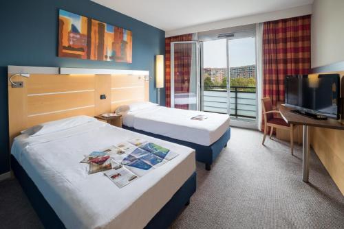 都灵托瑞诺米拉费欧瑞创意酒店的酒店客房设有两张床和一台平面电视。