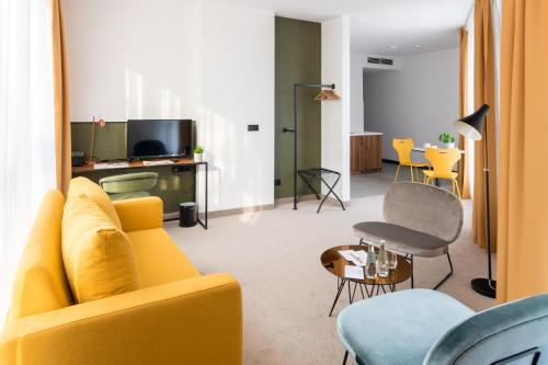 卢布林Arche Hotel Lublin的客厅配有黄色的沙发和桌子