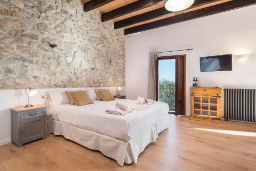 塞尔瓦坎卡洛新卡夫丽斯酒店的一间卧室设有一张大床和石墙