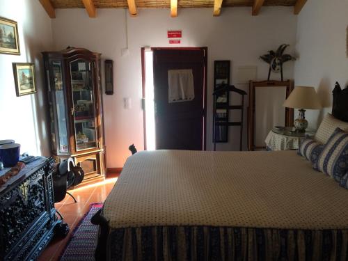 塞卡尔Quarto Monte Ninho das Perdizes的卧室,卧室配有一张床,卧室位于带门的房间