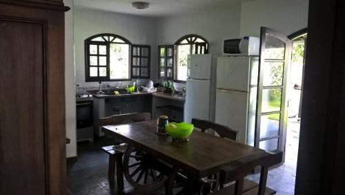 JuréiaCasa, quarto inteiro e quarto compartilhado Juréia的厨房配有木桌,上面有绿色碗
