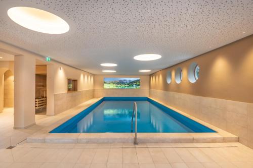 恩斯塔尔豪斯Bliem's Familienhotel的游泳池位于酒店带天花板的客房