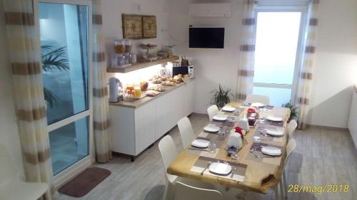 圣维托罗卡波Fra lu Mari的一间带长桌的用餐室和一间厨房
