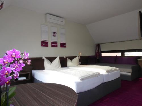 MainstockheimPension am Weinberg Bed & Breakfast的一间卧室配有床、沙发和鲜花
