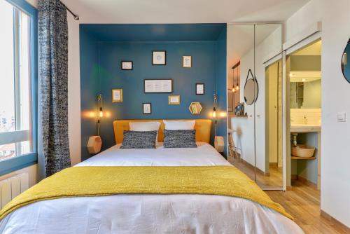 库尔布瓦Home Chic Home - Studio Paris La Défense - Les Toits de Courbevoie的一间卧室设有一张大床和蓝色的墙壁