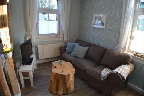塔巴尔茨Ferienwohnung "Auszeit"的客厅配有沙发和树 ⁇ 咖啡桌