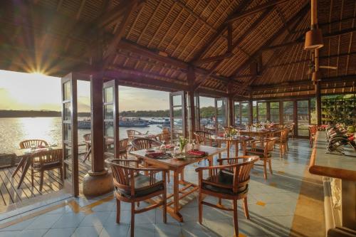 班尤温当迈批梦岩甘酒店的一间带桌椅并享有水景的餐厅