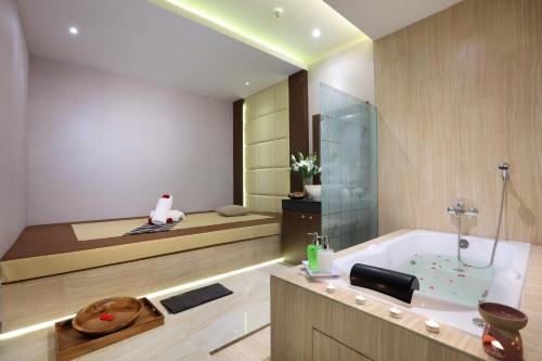 巨港Harper Palembang by ASTON的带浴缸和床的浴室