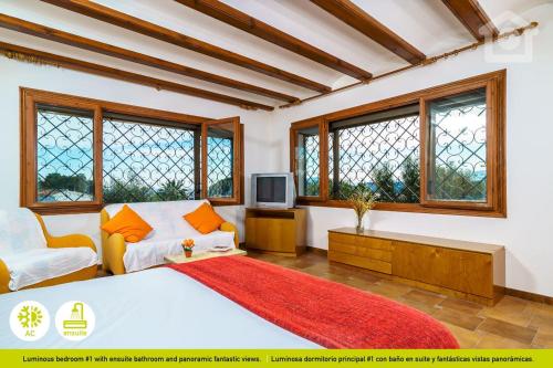 莫莱拉Solhabitat Villa Oasis的一间卧室设有一张床、一台电视和窗户。