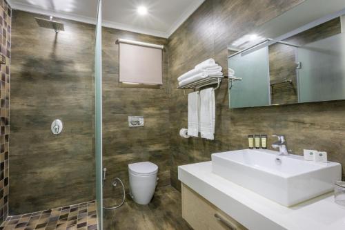 卢萨卡Fallsway Suites的一间带水槽、卫生间和镜子的浴室