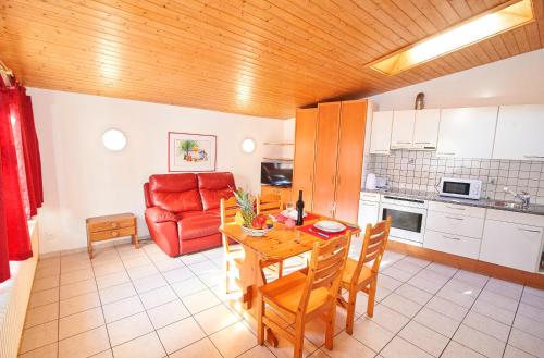 因特拉肯少女峰住宅公寓的厨房配有桌子和红色沙发