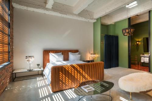 第比利斯斯坦巴酒店的一间设有床铺的卧室,位于一个拥有绿色墙壁的房间