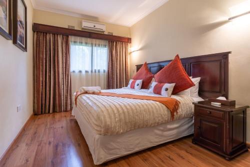 卢萨卡Fallsway Apartments - Burley Court的一间卧室设有一张大床和一个窗户。